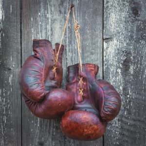 Old boxing gloves hanging on a wooden wall